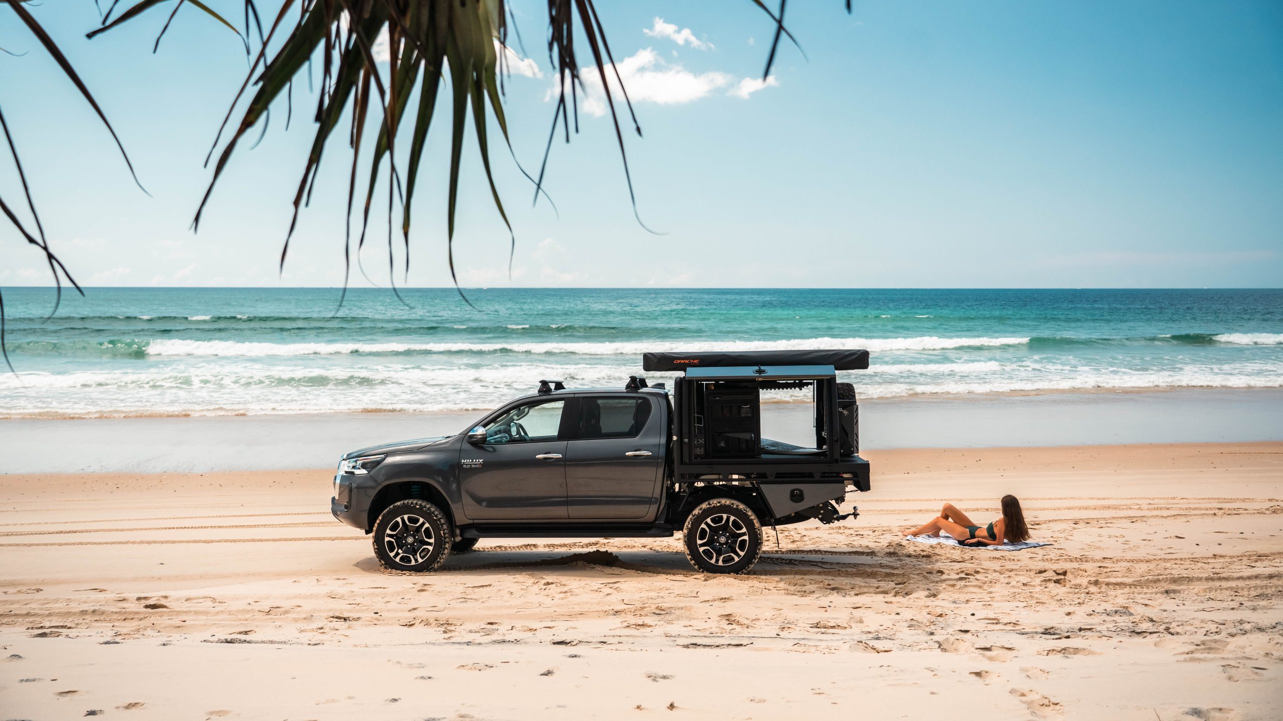 Grey Toyota Hilux with matching Buffalo canopy setup on the beach