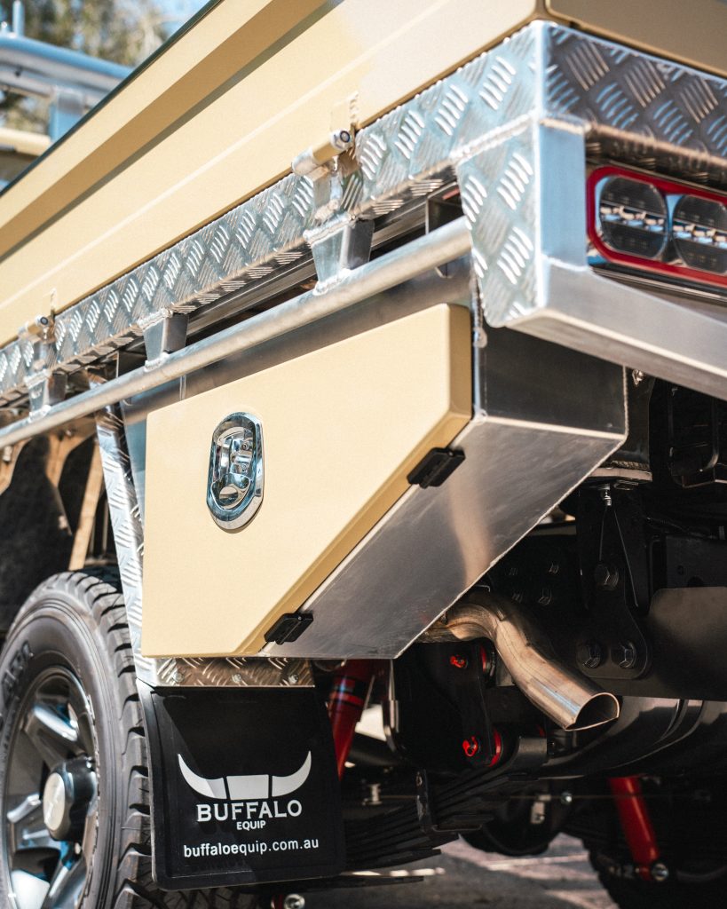 Taupe 79 Series Landcruiser with Buffalo Tray with and Semi Departure Toolboxes behind the wheels.